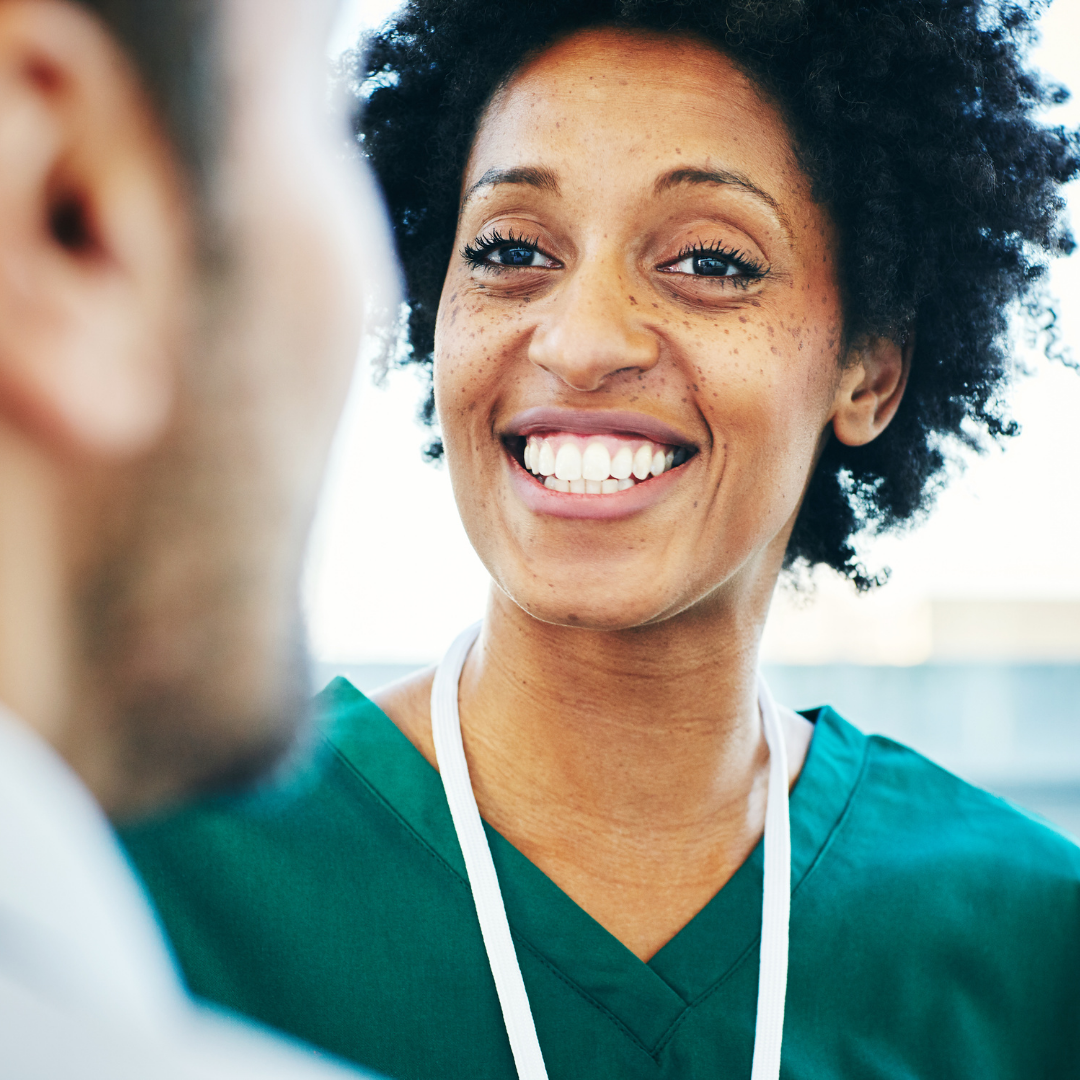 Female Nurse Leader Smiling Talking to a Doctor