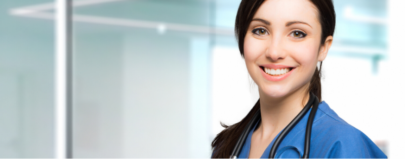 Brown Haired Nurse Smiling in Dark Blue Scrubs